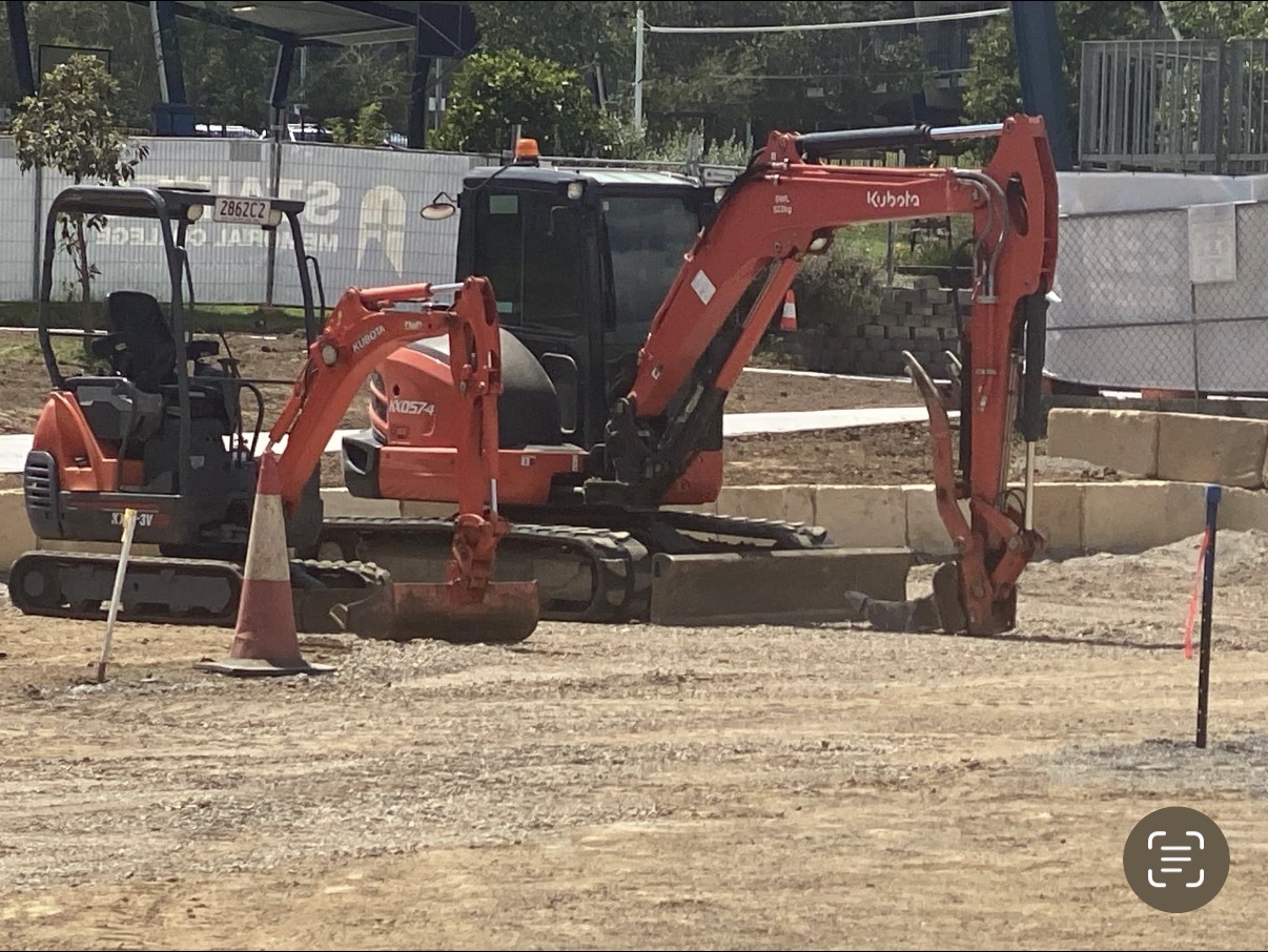 Two Kubota excavators working on a prepared construction site