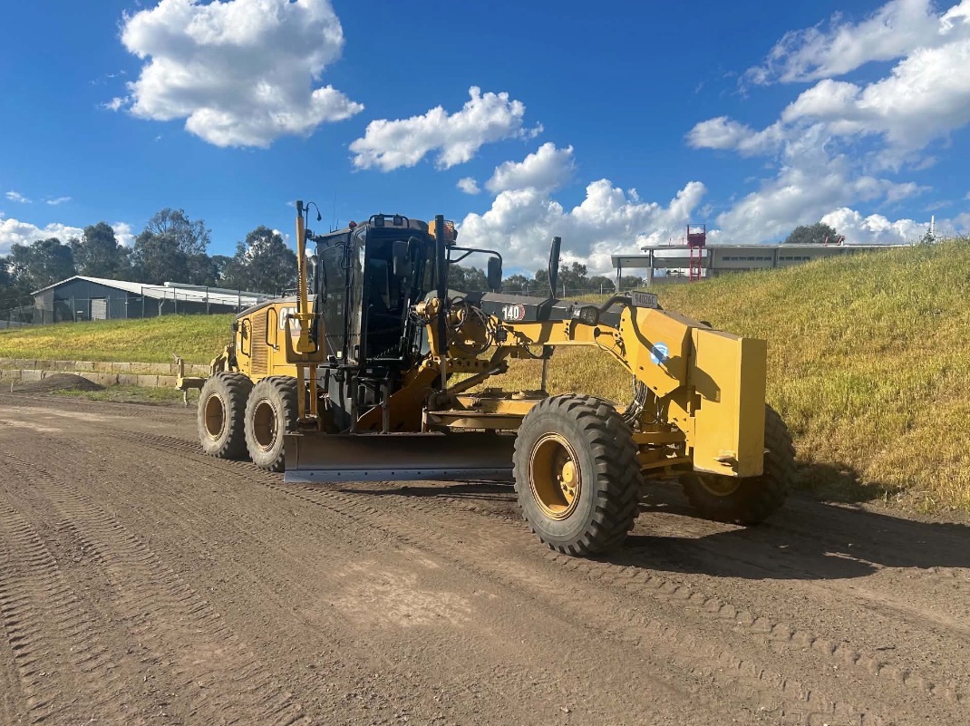 Motor grader preparing and levelling a road surface